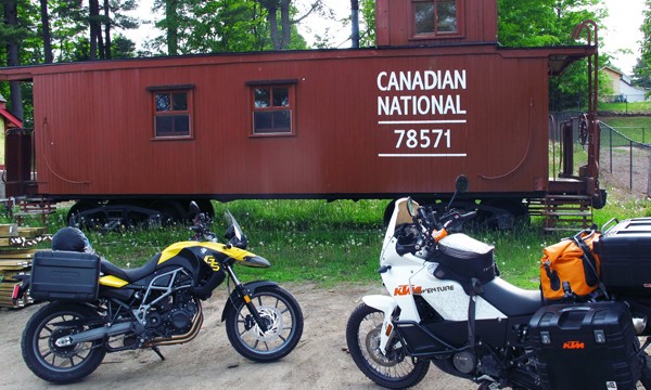 Two motorcycles in front of a rail car