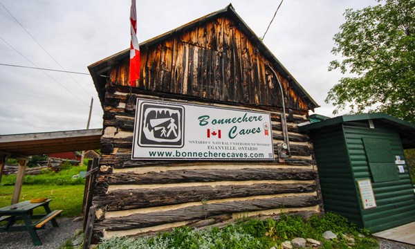 Log Building with Bonnechere Caves sign