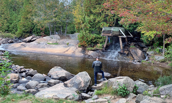 Man in front of log chute