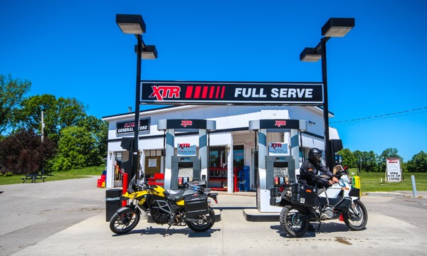 Two motorcycles at gas pumps