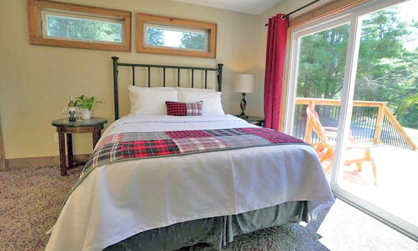  Queen size bed with buffalo print decor beside sliding door. 