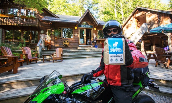 Rider on Bike holding bag of coffee beans