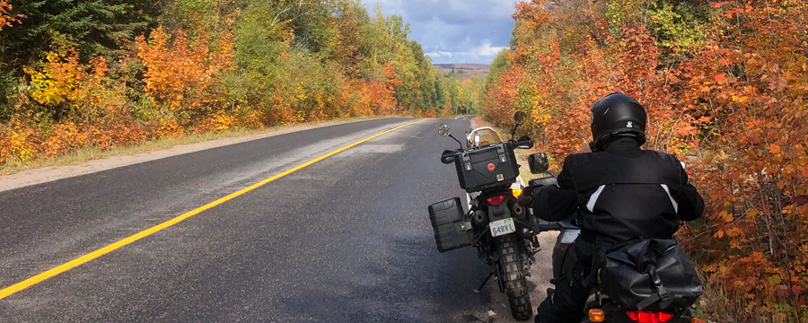 Two motorcycles on side of road with fall colours