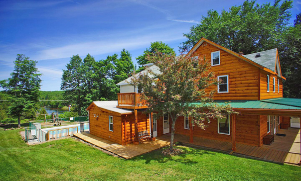  exterior of lodge and swimming pool. Lake in the background.