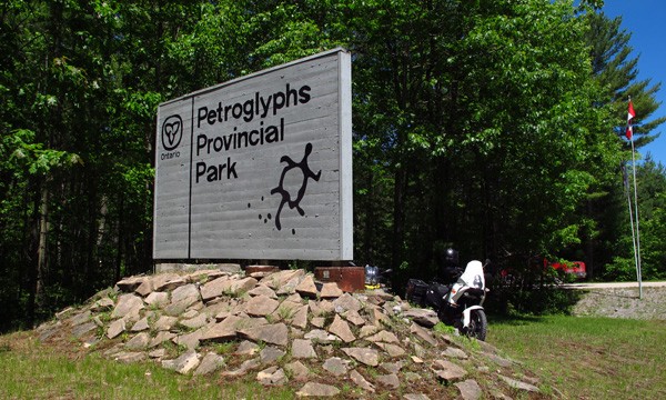 Motorcycle beside a sign that reads Petroglyphs Provincial Park