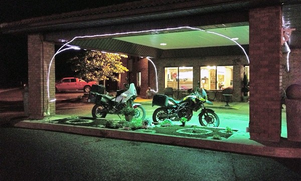 Two motorcycles under a building overhang