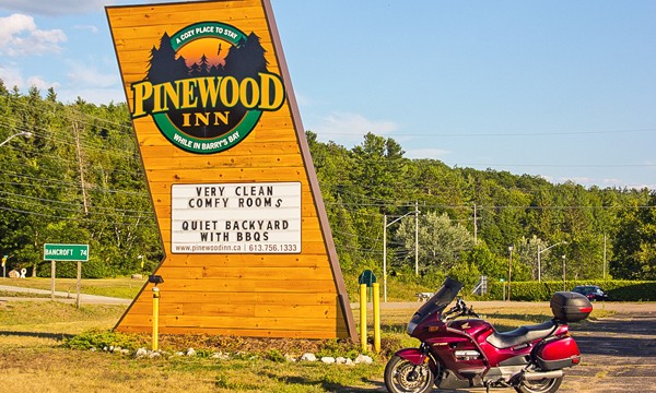 Motorcycle beside Pinewood Inn sign