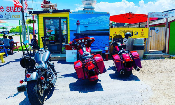 Two motorcycles in front of food stand