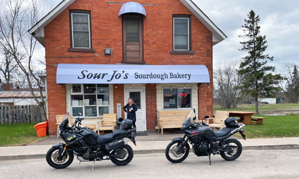 Two motorcycles in front of bakery